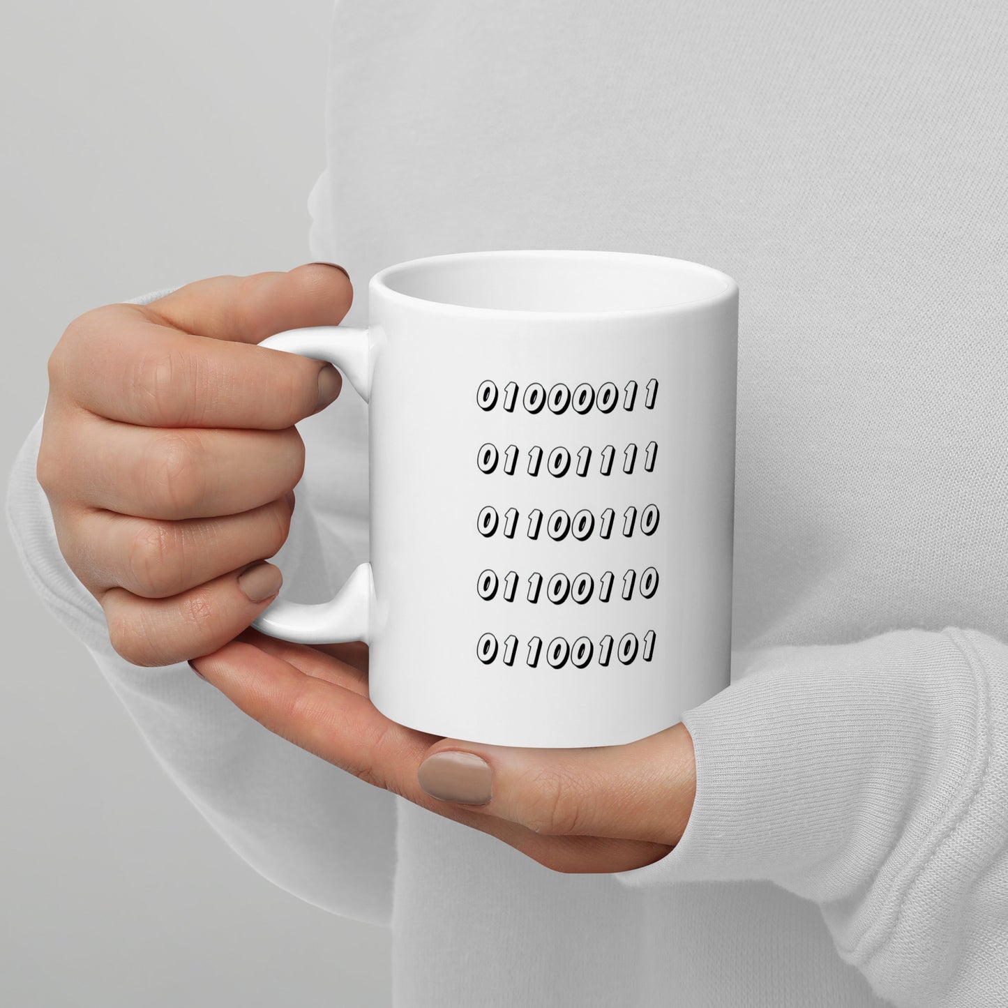 White 11oz tech humor coffee mug featuring the word “Coffee” written in binary with handle on the left.