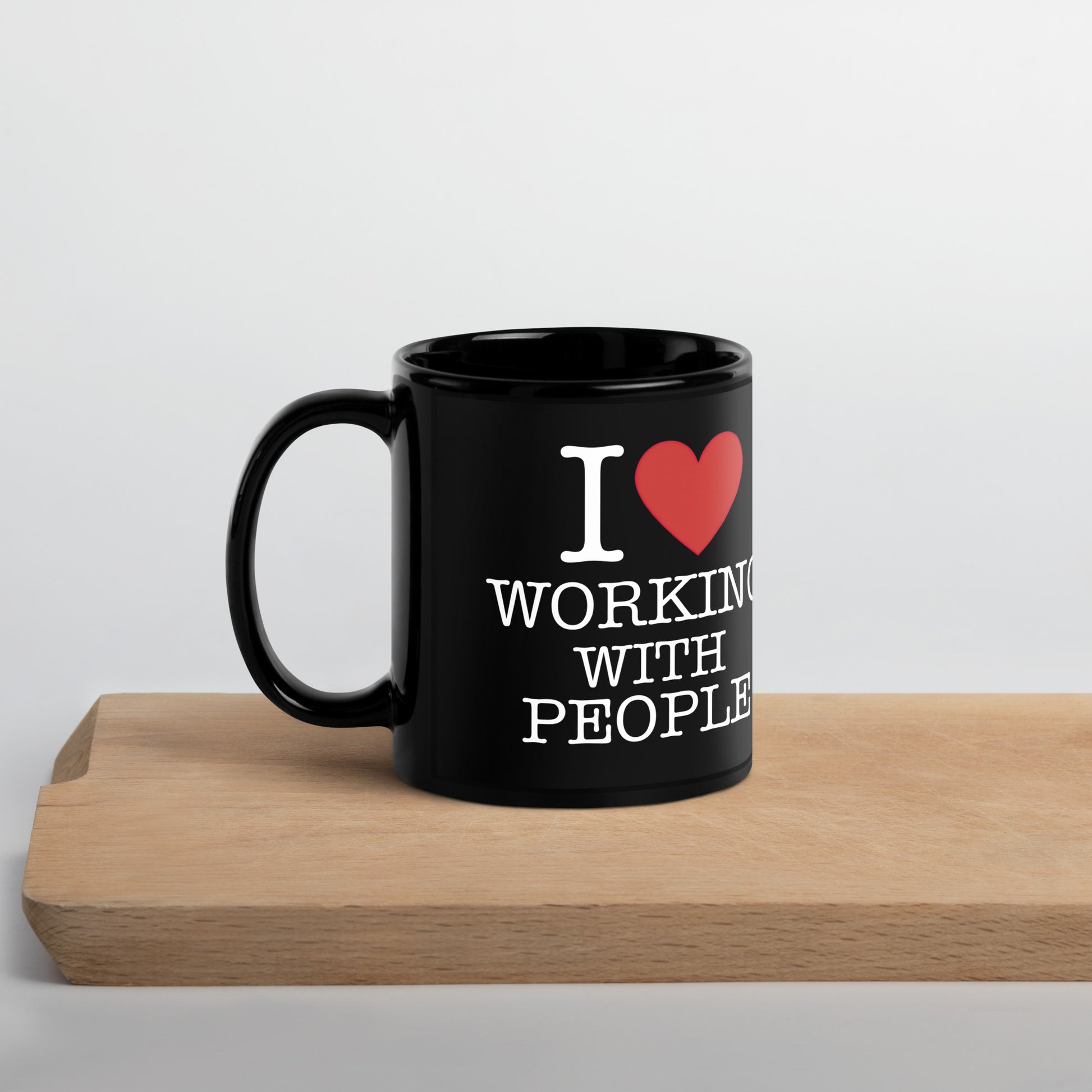 Black 11oz tech humor coffee mug with an I Love NY style design that reads ‘I Love Working With People’ with handle on left.