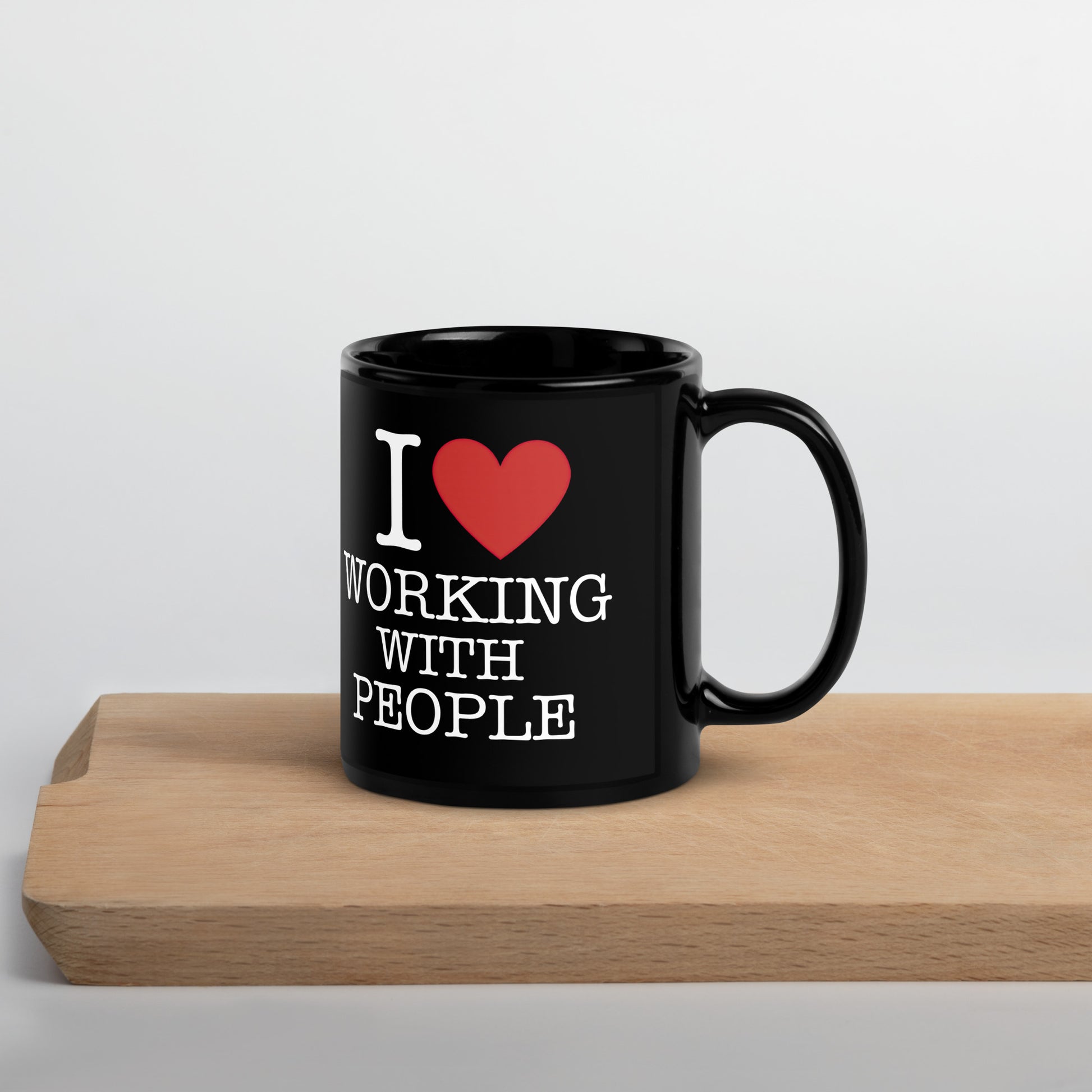 Black 11oz tech humor coffee mug with an I Love NY style design that reads ‘I Love Working With People’ with handle on right