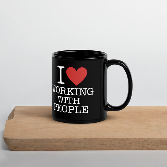 Black 11oz tech humor coffee mug with an I Love NY style design that reads ‘I Love Working With People’ with handle on right