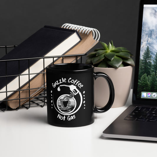 Black 11oz EV themed coffee mug with a gas pump filling a coffee cup and slogan ‘Guzzle Coffee, Not Gas’ with handle on right.