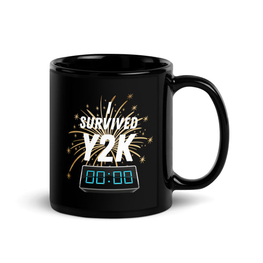 Black 11oz tech humor coffee mug with a design of fireworks and a digital clock at midnight that reads ‘I Survived Y2K’