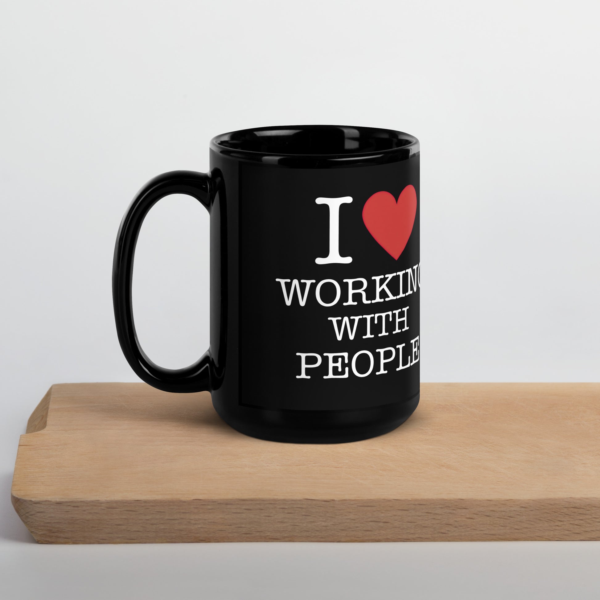 Black 15oz tech humor coffee mug with an I Love NY style design that reads ‘I Love Working With People’ with handle on left.