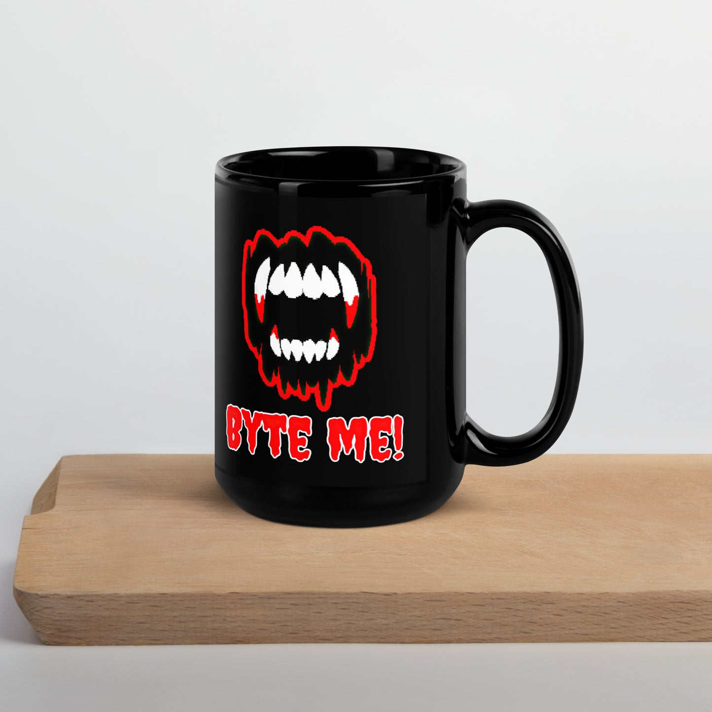 Black 15oz tech humor Halloween coffee mug featuring slogan “Byte Me!” under pixelated vampire fangs with handle on the right