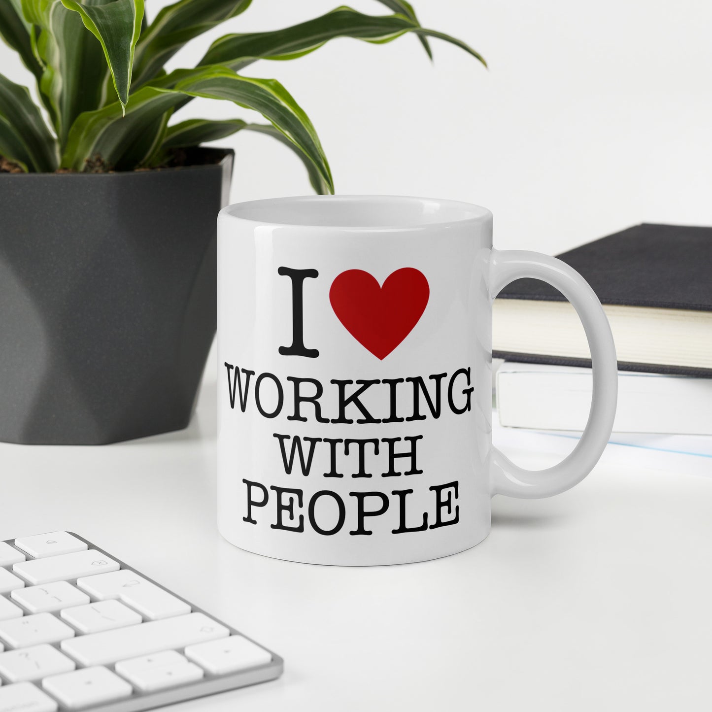 White 11oz tech humor coffee mug with an I Love NY style design that reads ‘I Love Working With People’ with handle on right