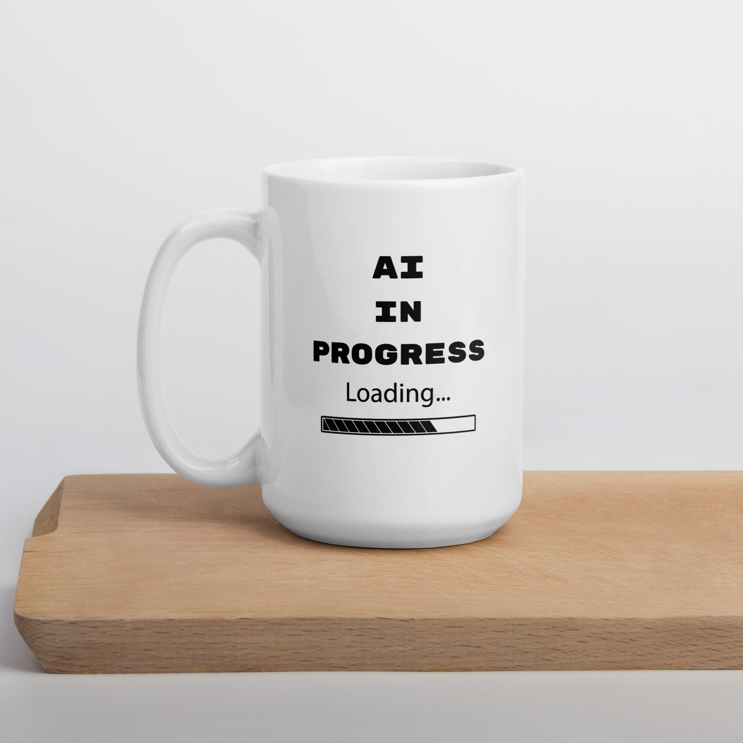 White 15oz tech humor and AI coffee mug featuring slogan “AI in Progress” with handle on the left.