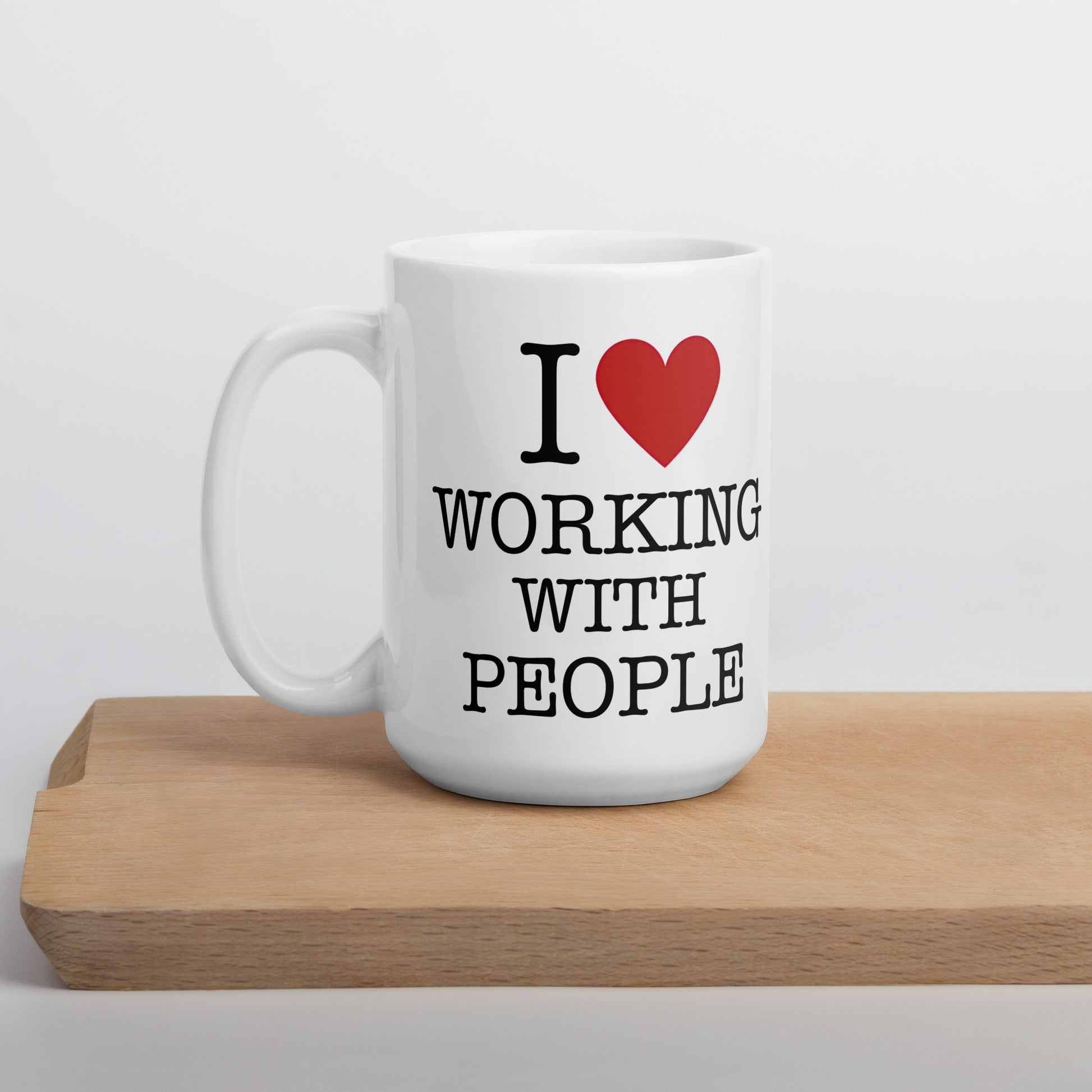 White 15oz tech humor coffee mug with an I Love NY style design that reads ‘I Love Working With People’ with handle on left.