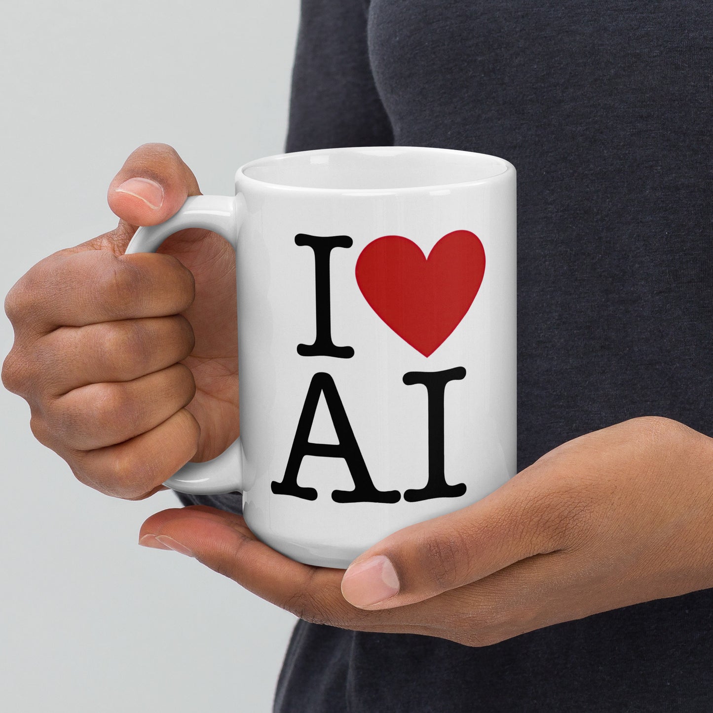 White 15oz AI themed coffee mug with an I Love NY type slogan ‘I Love AI’ with handle on left being held by a man.