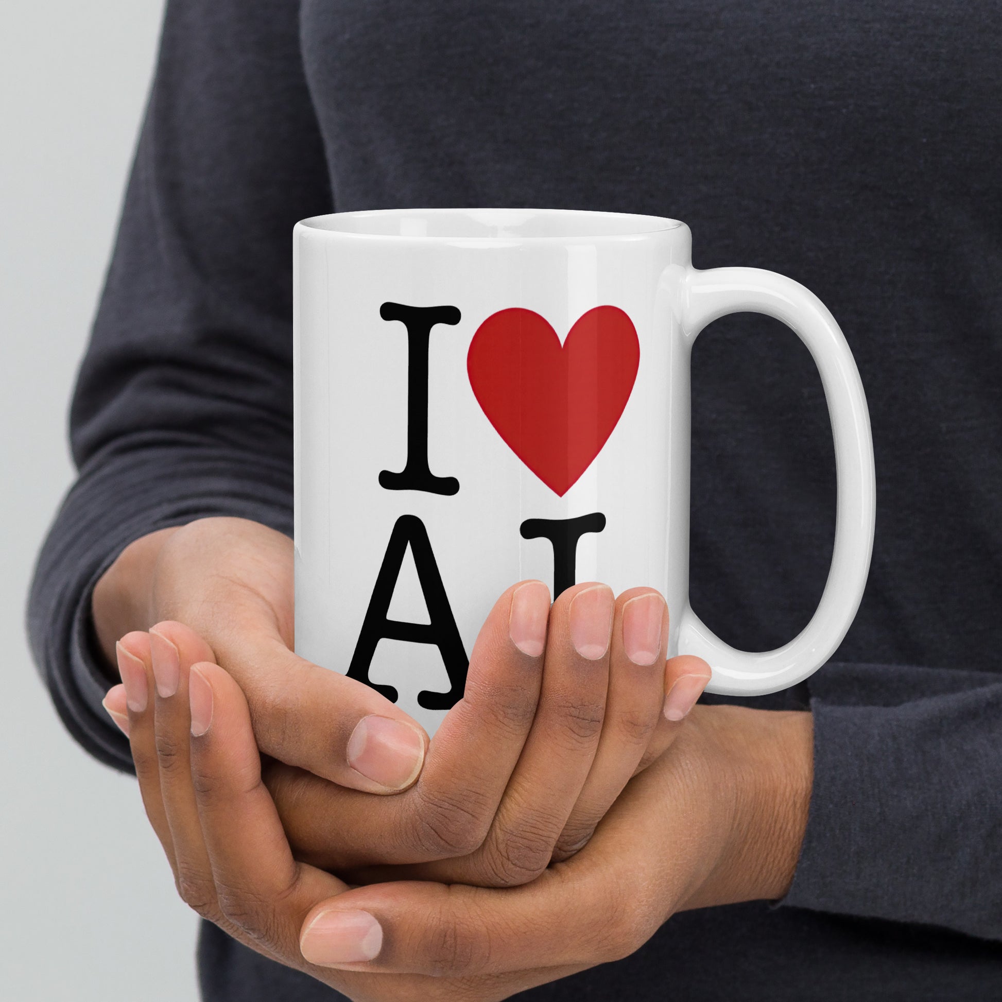 White 15oz AI themed coffee mug with an I Love NY type slogan ‘I Love AI’ with handle on right held by man.