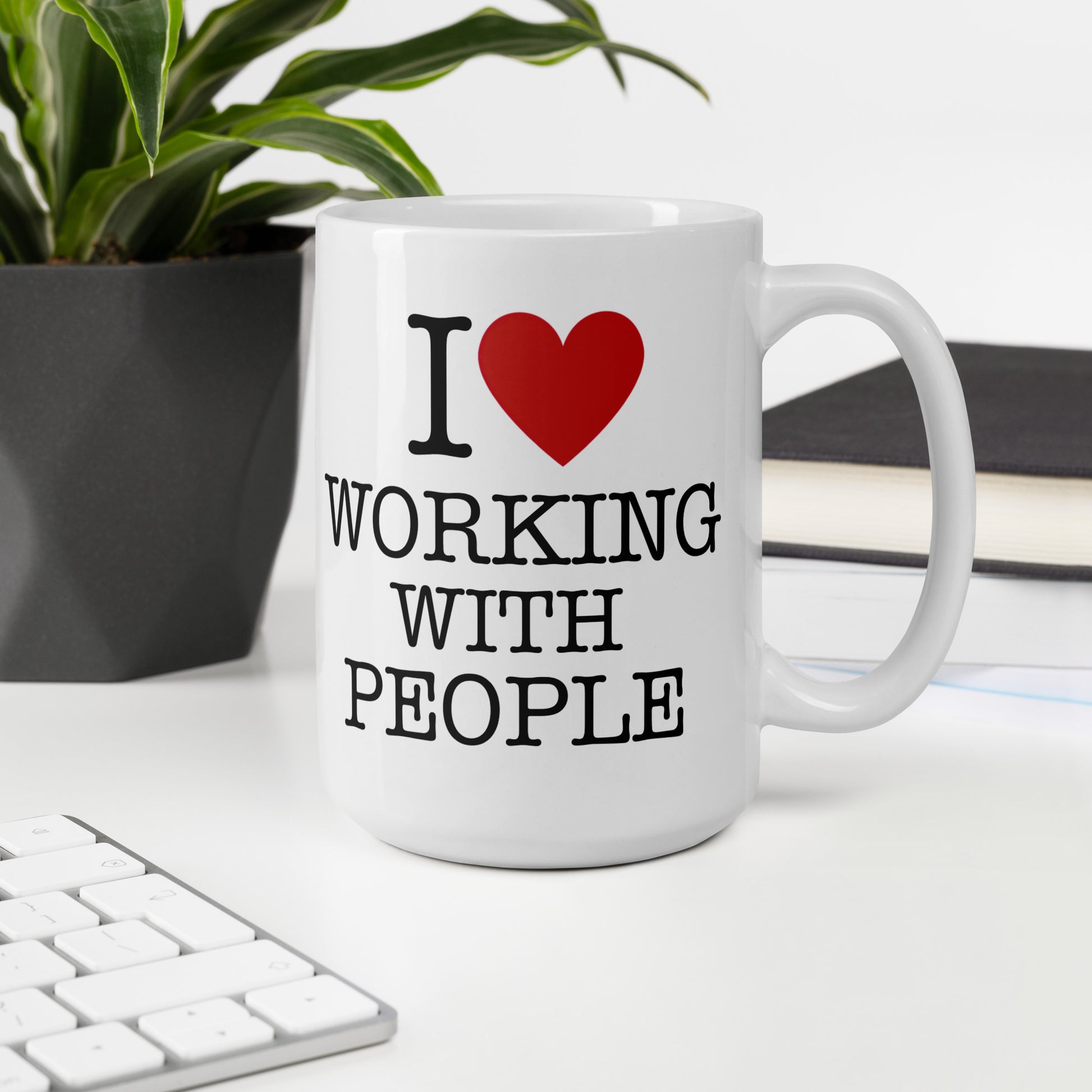 White 15oz tech humor coffee mug with an I Love NY style design that reads ‘I Love Working With People’ with handle on right