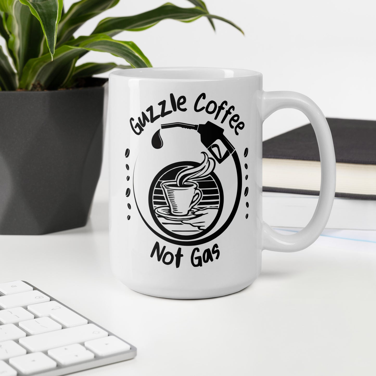 White 15oz EV themed coffee mug with a gas pump over a coffee cup and slogan ‘Guzzle Coffee, Not Gas’ with handle on right on desk.